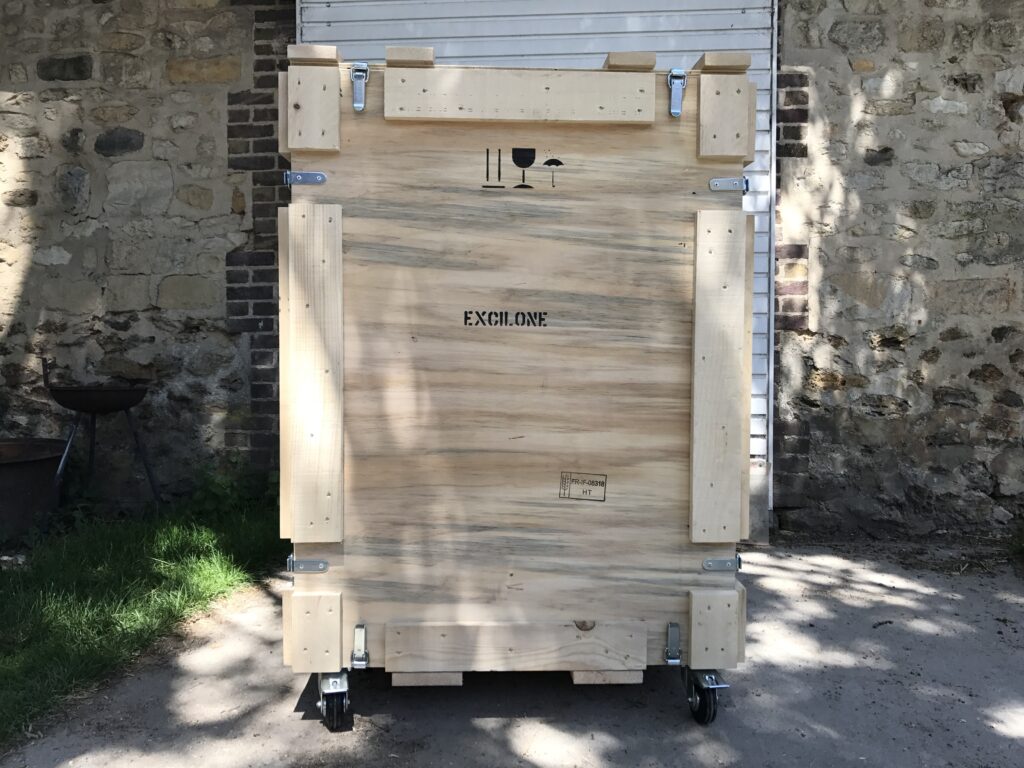 Caisse en bois sur mesure équipée de grenouillères pour assurer une ouverture rapide sans outillage, ainsi que de roulettes pour faciliter la manipulation.